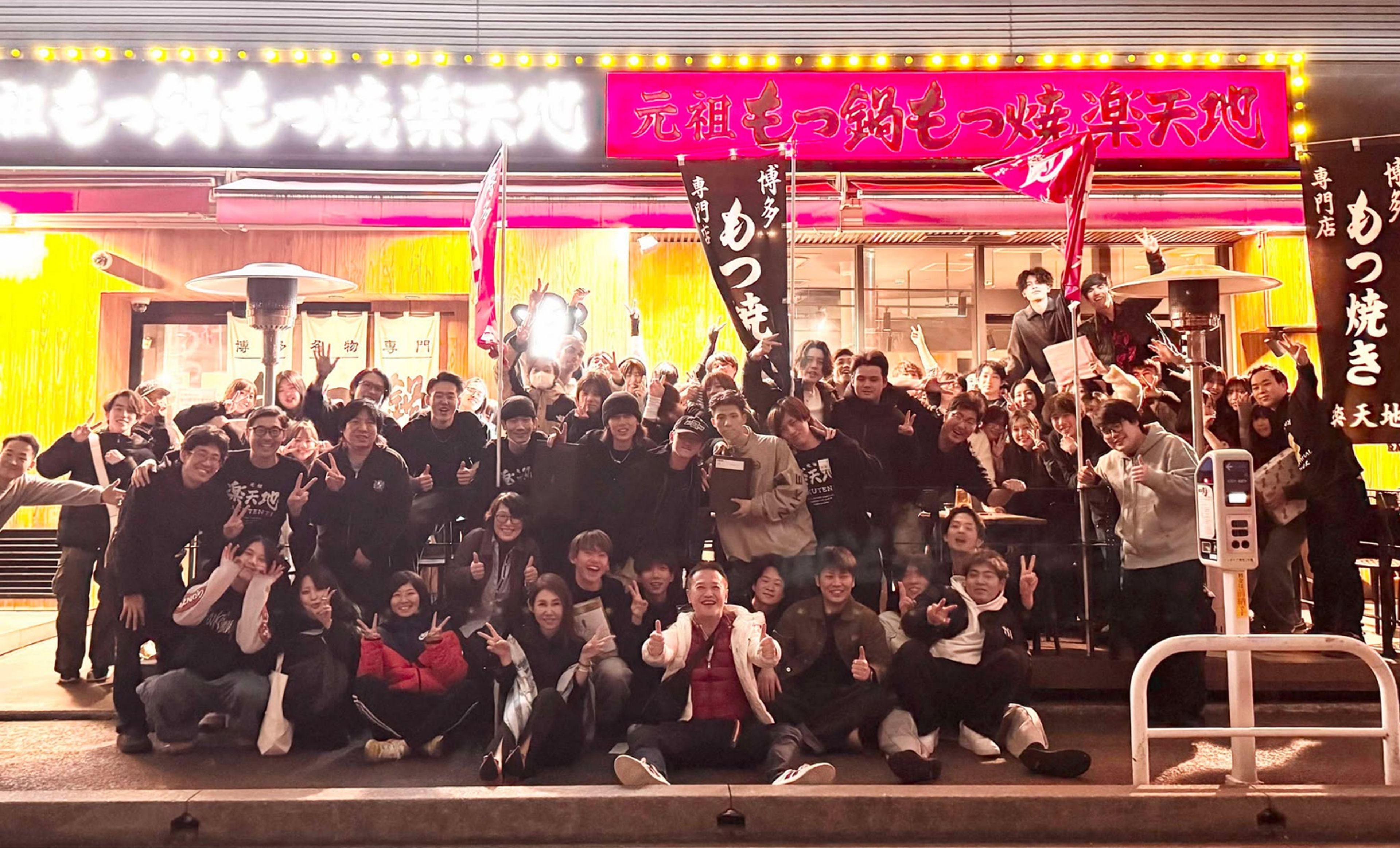 店舗の前で集合写真を撮っている様子